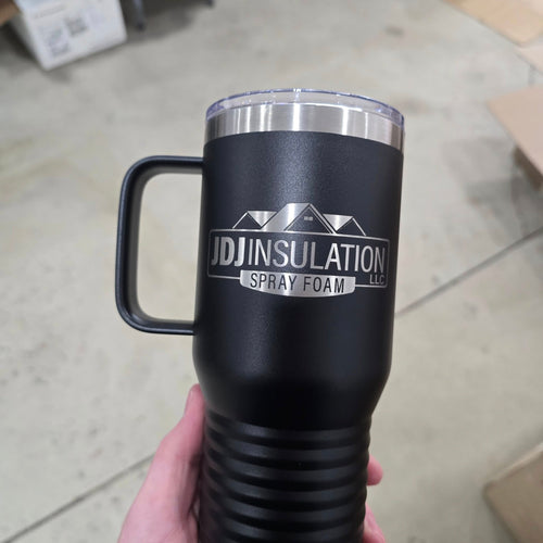 Black insulated mug with 'UDJ Insulation Spray Foam LLC' logo held in a hand on a tiled floor.